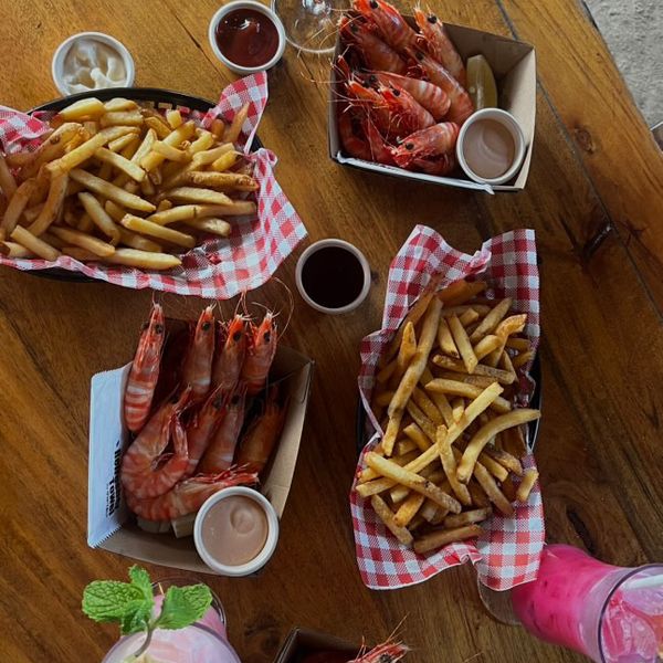 trays of prawns and chips on a wooden table