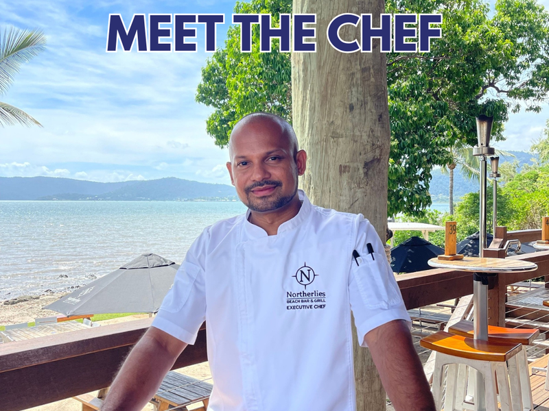 Head chef of Northerlies standing on the deck with the beach behind