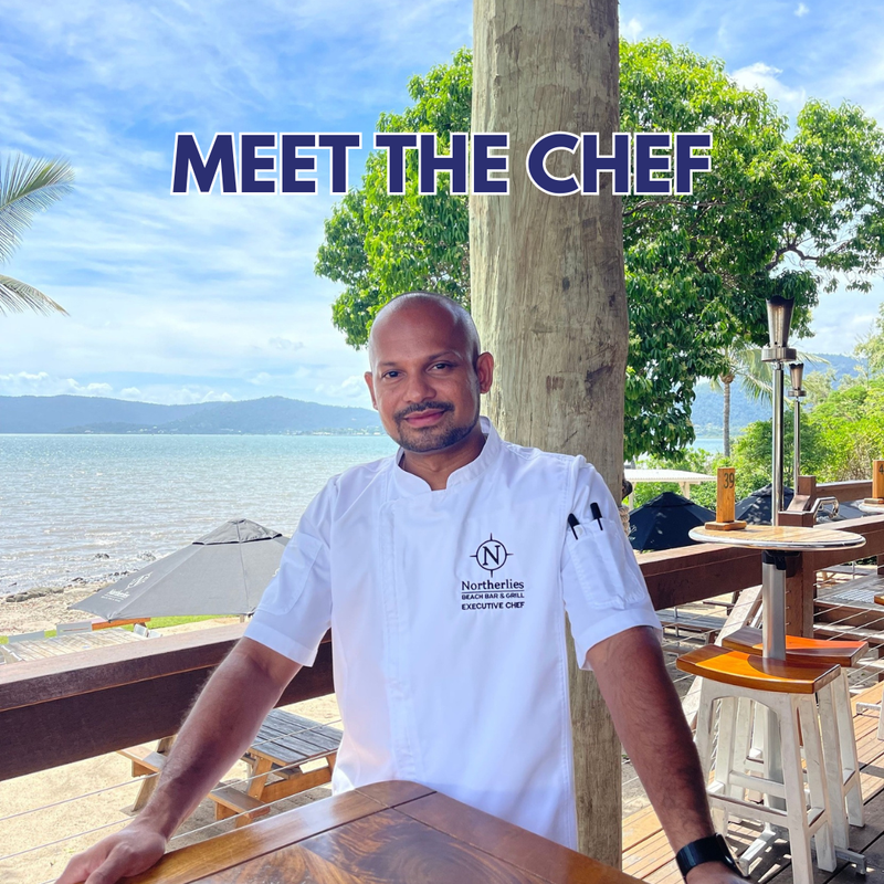 Head chef of Northerlies standing on the deck with the beach behind